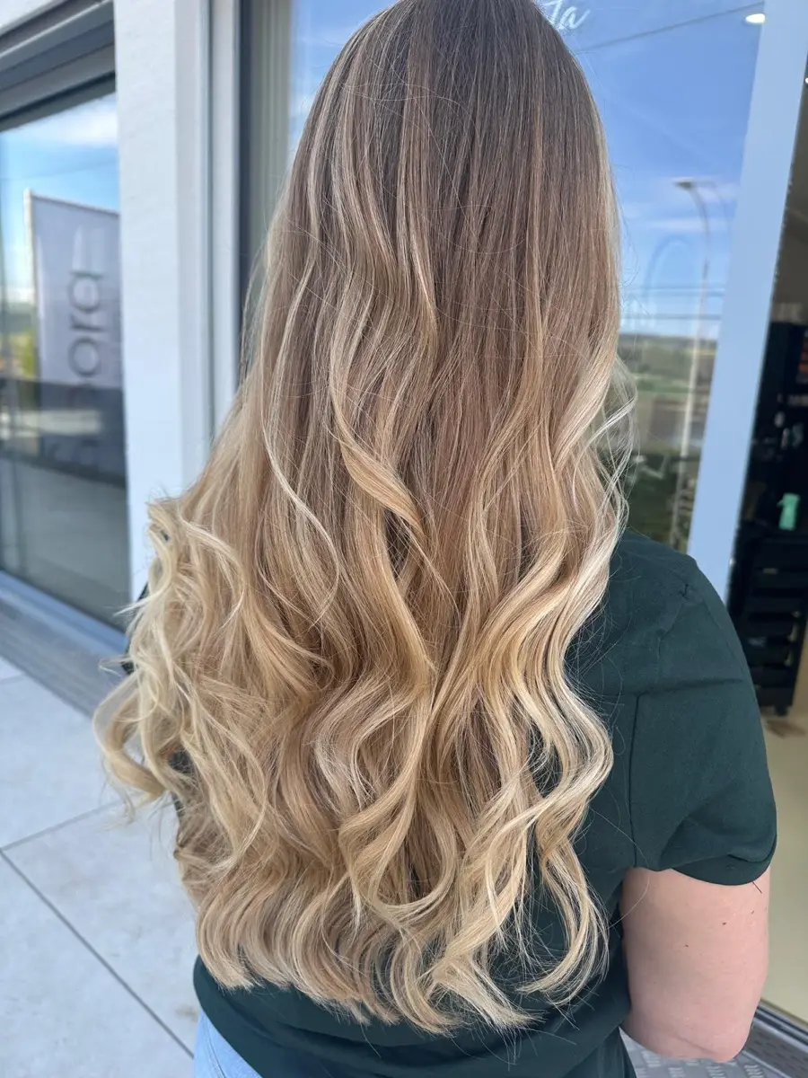 Balayage in warmem Blond mit weichen Wellen